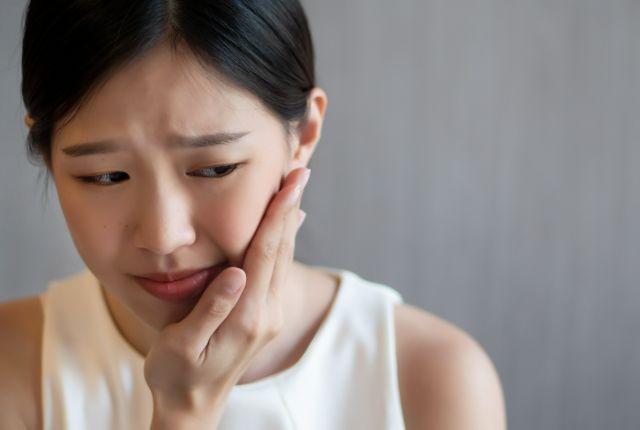 歯の痛みを感じる女性